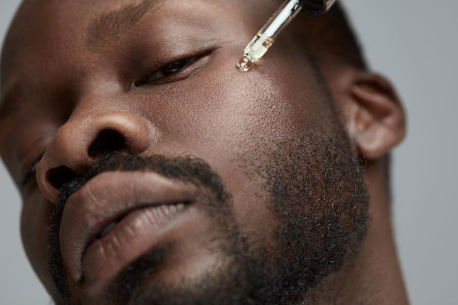 man putting serum on face